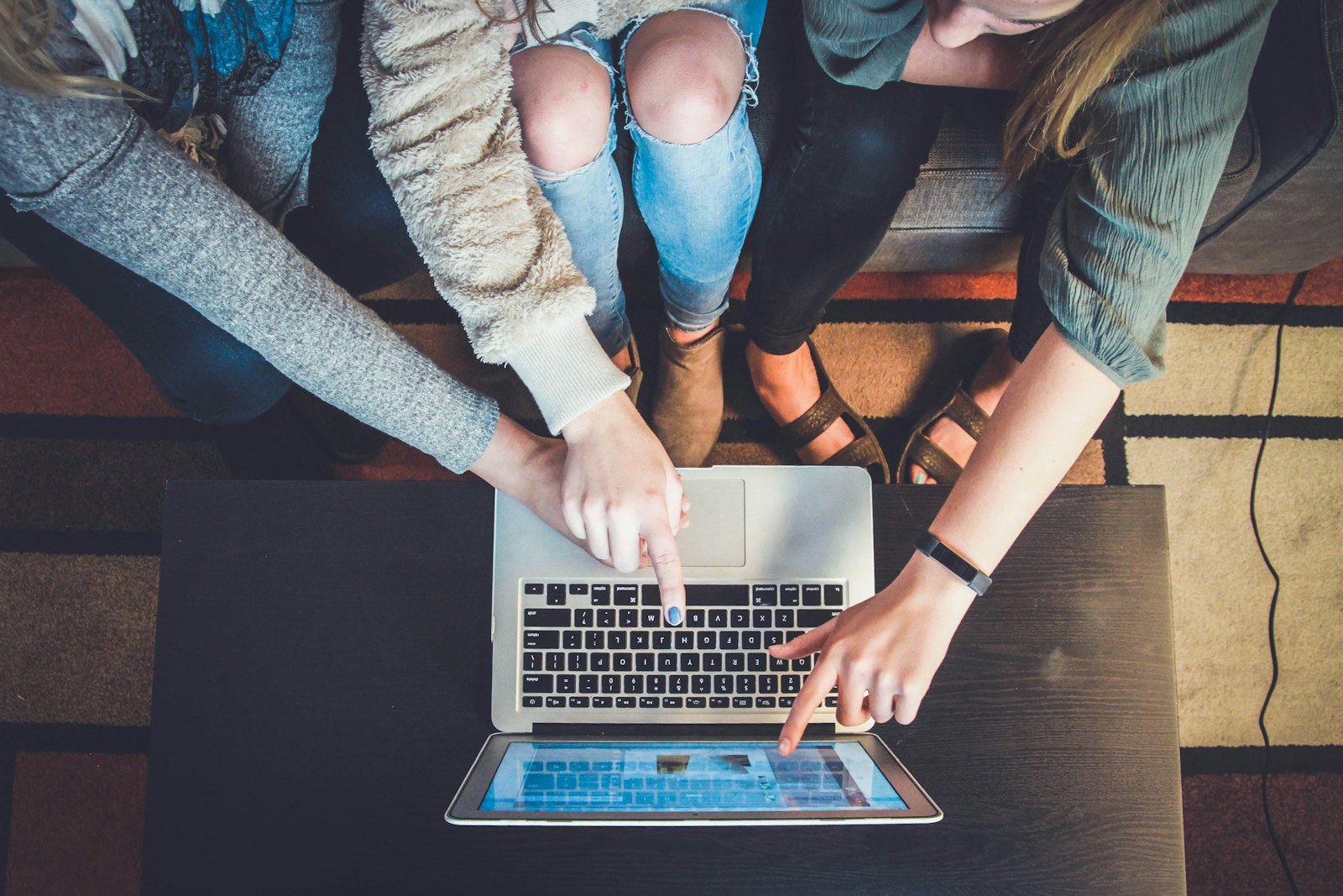 Personas colaborando alrededor de una computadora en un entorno profesional